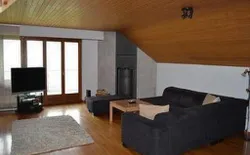 Bild 2: Wohnzimmer mit Sofa und Speicherofen