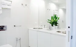 Bild 11: All white bathroom with double sink, large mirror on the wall, wc and bidet.