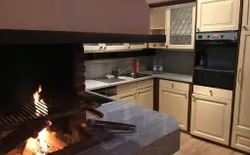 Bild 13: Voll ausgestattete Küche mit integriertem Cheminee 
Geschirrspülmaschine Backofen grosser Kühlschrank mit Gefrierfach