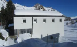 Bild 6: Winteransicht des Zweifamilienhauses.
Privater Wohnungseingang (unterhalb der Terrasse). Skiraum im Nebeneingang.