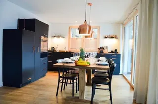 Bild 2: Moderne, gut ausgestattete Küche mit grossem Esstisch